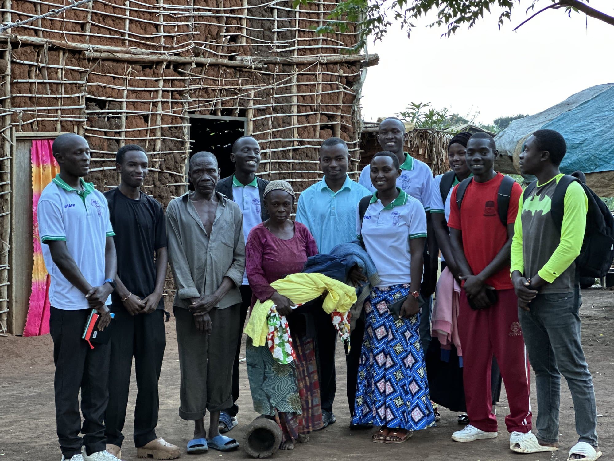 STAC staff and volunteers with a family they serve in Kyangwali