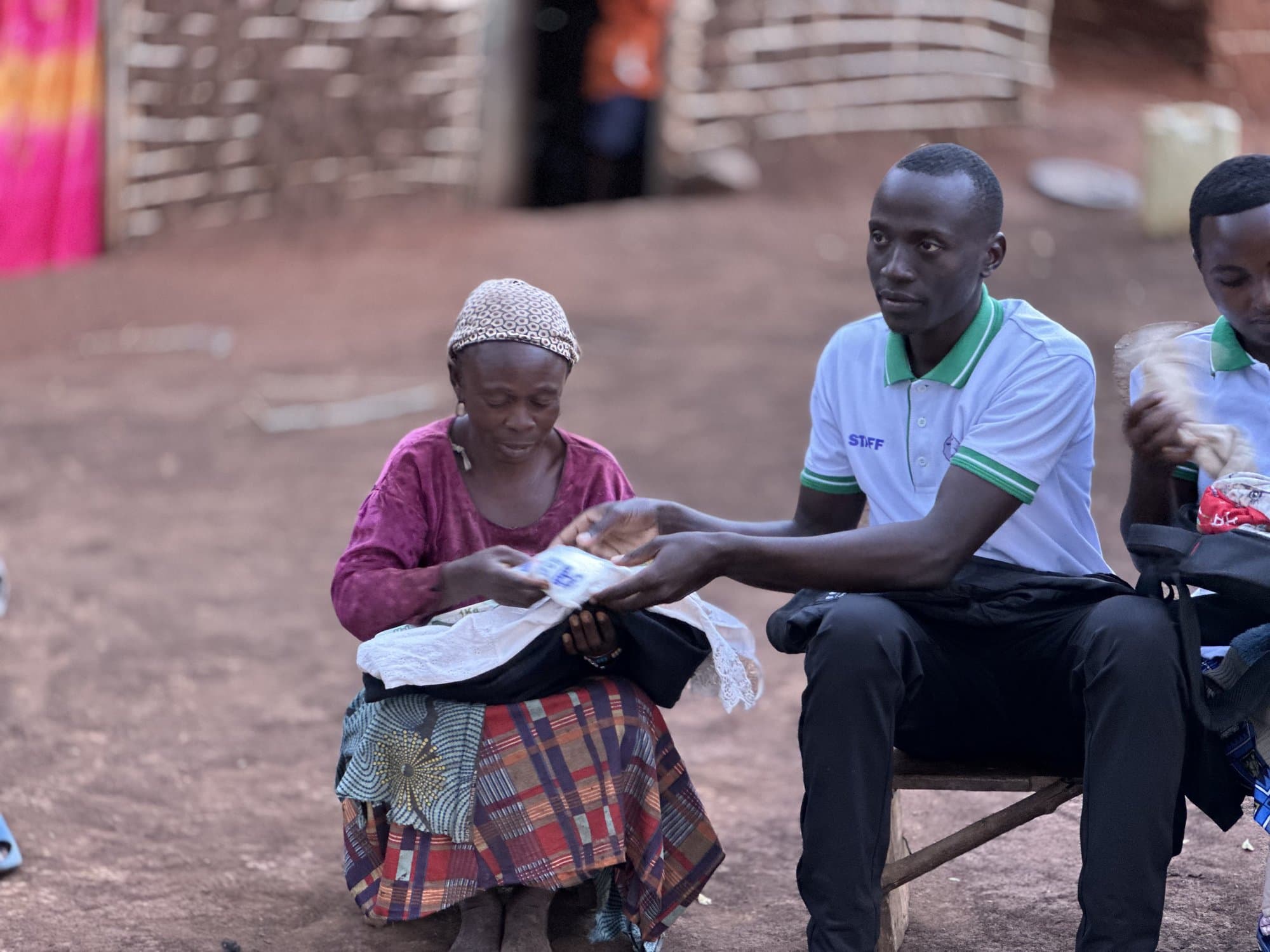 A STAC team member handing supplies to a community member